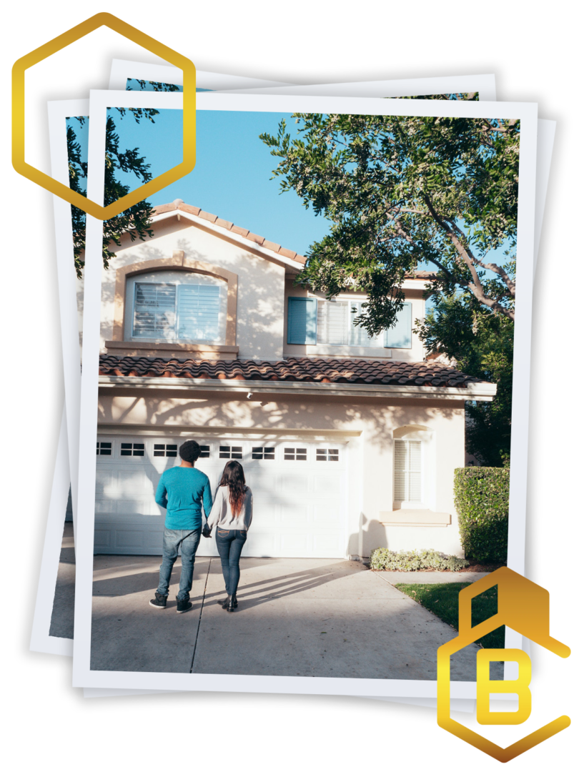 A couple standing in front of their home.